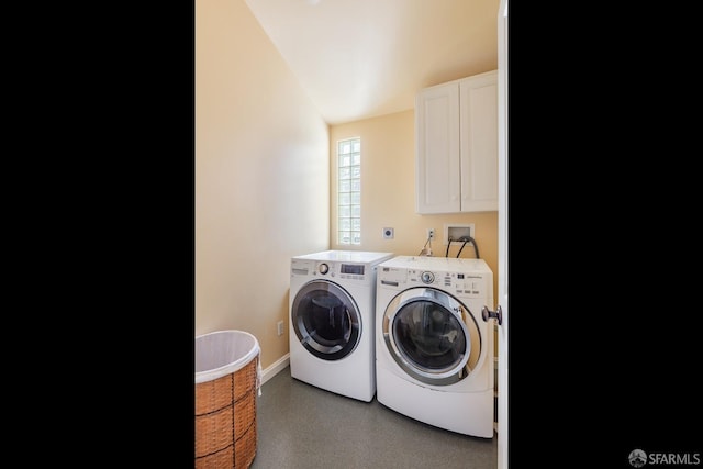 clothes washing area featuring baseboards, cabinet space, and washing machine and dryer
