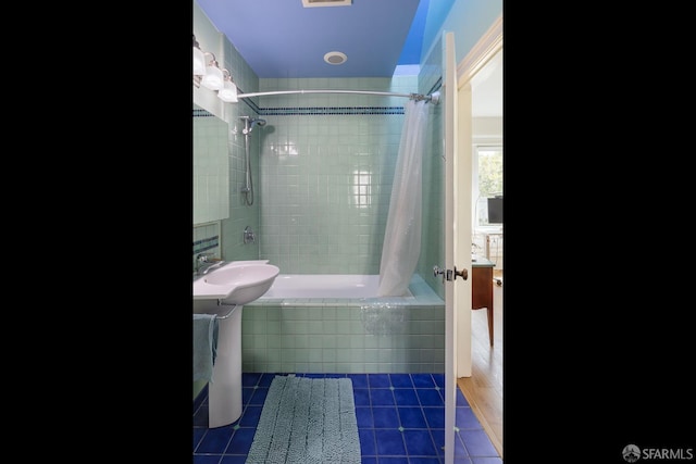 bathroom featuring a sink, tile patterned flooring, and tiled shower / bath