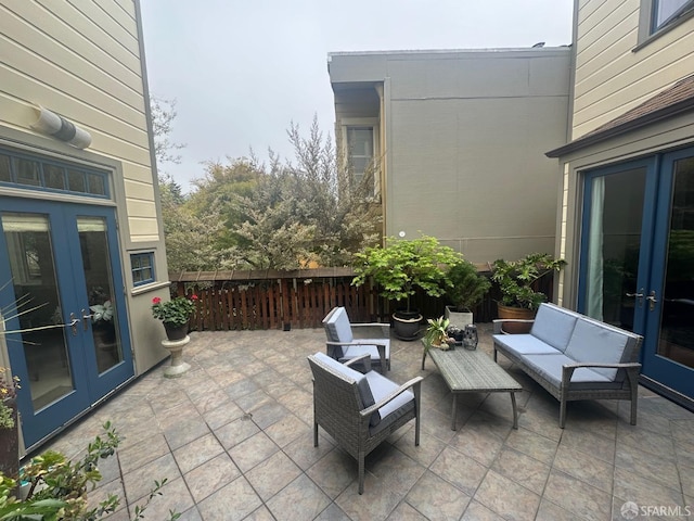 view of patio with an outdoor living space, fence, and french doors
