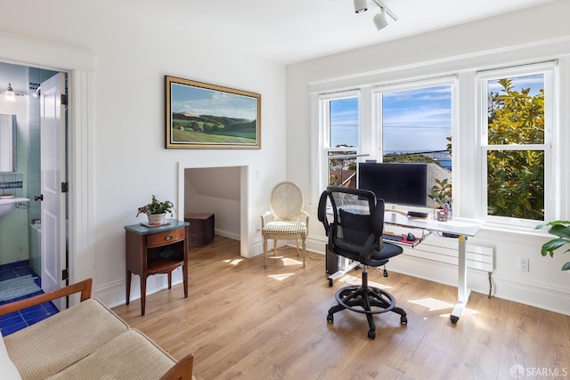 home office with baseboards and light wood finished floors