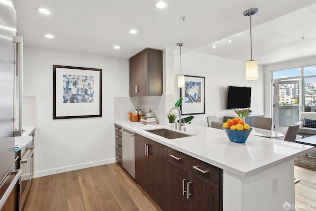 2655 Bush St Unit 603, San Francisco, CA 94115 - kitchen featuring light wood finished floors, a sink, a peninsula, appliances with stainless steel finishes, and open floor plan