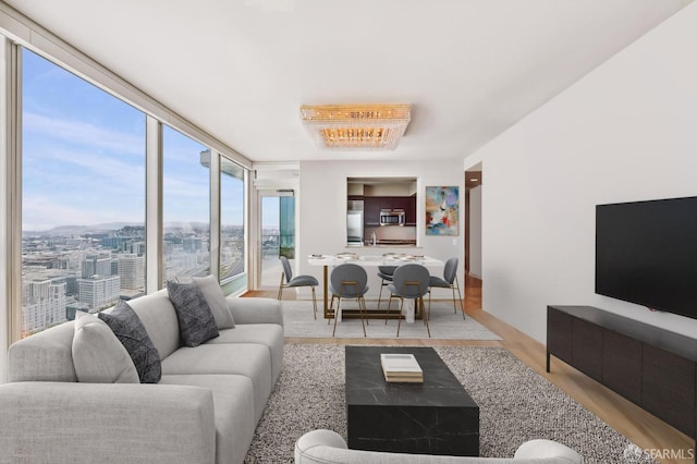 living room with expansive windows and light hardwood / wood-style floors