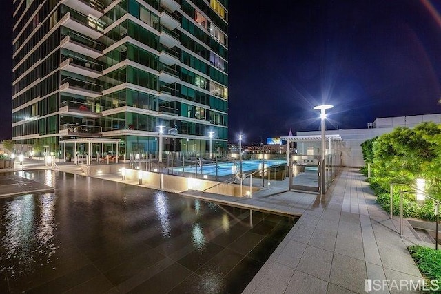 pool at night with tennis court