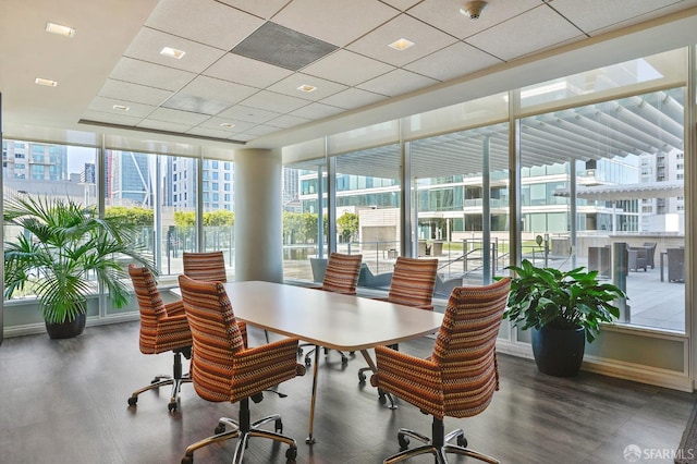 home office with a drop ceiling and dark wood-type flooring