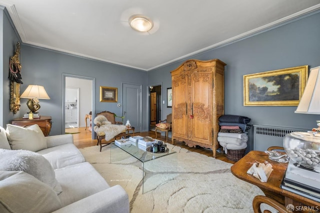 living room with radiator, wood-type flooring, and crown molding