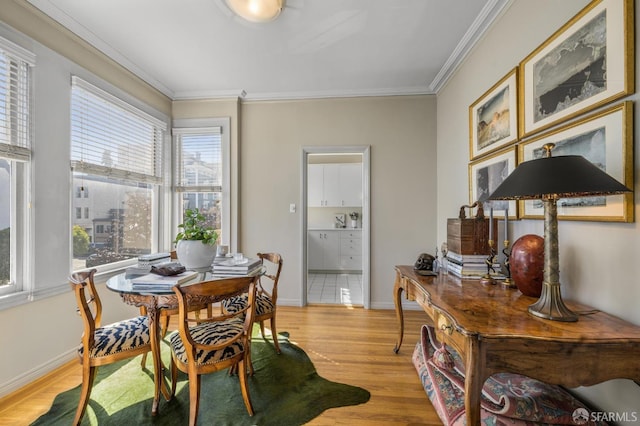 dining area with ornamental molding and light wood-type flooring