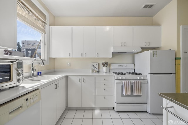 kitchen featuring light tile patterned flooring, white appliances, sink, and white cabinets