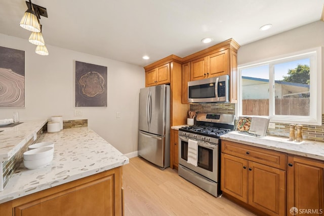 4649 Theta St, Fremont, CA 94536 - kitchen featuring stainless steel appliances, light wood-style flooring, backsplash, brown cabinets, and light stone counters