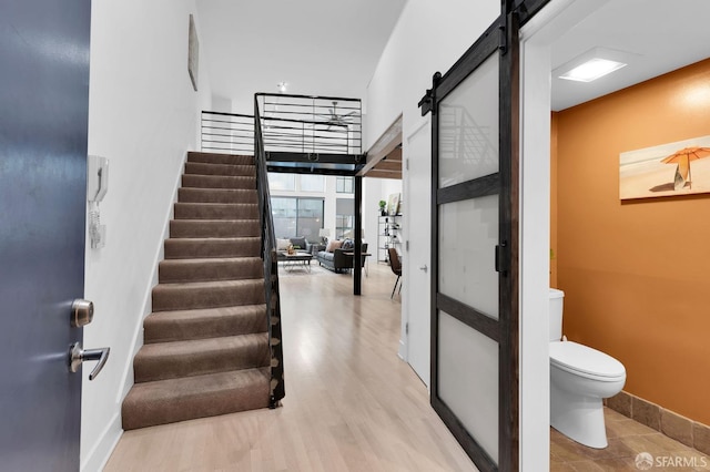 stairs with hardwood / wood-style flooring and a barn door