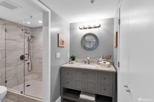 bathroom featuring vanity, toilet, and a shower with shower door