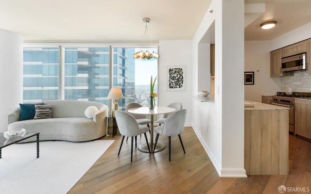 401 Harrison St Unit 25F, San Francisco, CA 94105 - dining space featuring light wood-type flooring, baseboards, and a chandelier