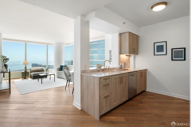 401 Harrison St Unit 25F, San Francisco, CA 94105 - kitchen with stainless steel dishwasher, wood finished floors, light stone countertops, a sink, and open floor plan