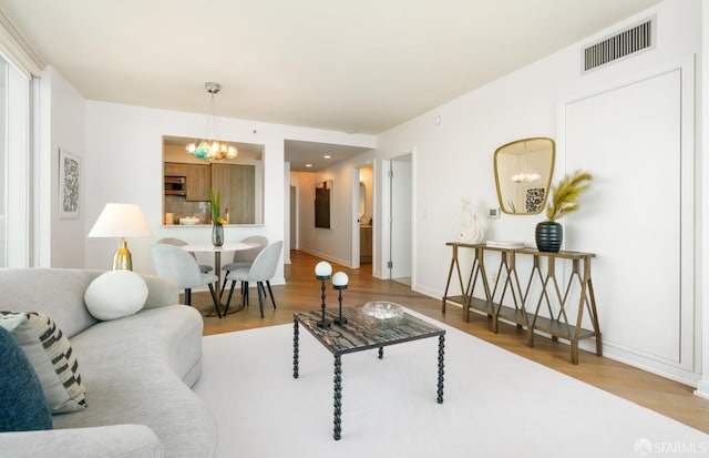 401 Harrison St Unit 25F, San Francisco, CA 94105 - living area featuring a chandelier, wood finished floors, and baseboards