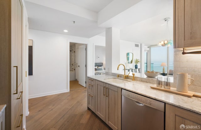 401 Harrison St Unit 25F, San Francisco, CA 94105 - kitchen featuring stainless steel dishwasher, a sink, hardwood / wood-style floors, light stone countertops, and recessed lighting