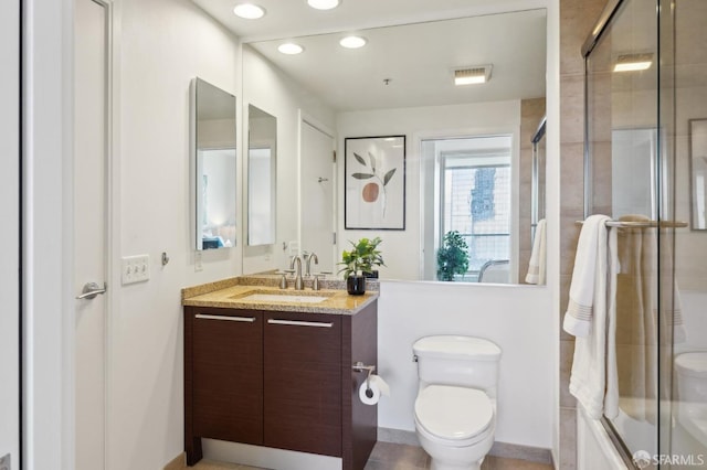 full bathroom featuring toilet, vanity, and bath / shower combo with glass door