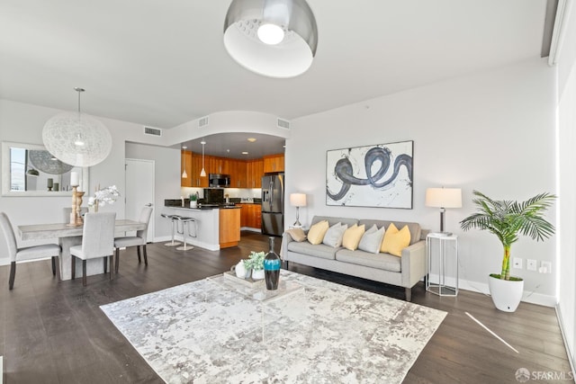 living room with visible vents, baseboards, and dark wood-style flooring