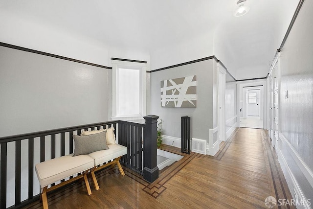 hall featuring baseboards, visible vents, and wood finished floors