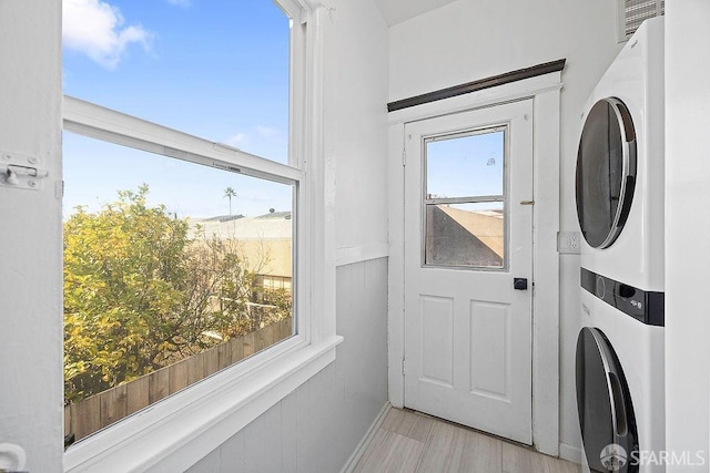 interior space featuring stacked washing maching and dryer, plenty of natural light, visible vents, and light wood-style floors