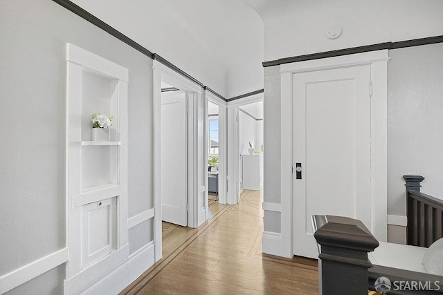 hallway featuring baseboards and wood finished floors