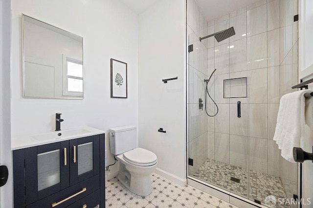 bathroom with a stall shower, baseboards, and toilet