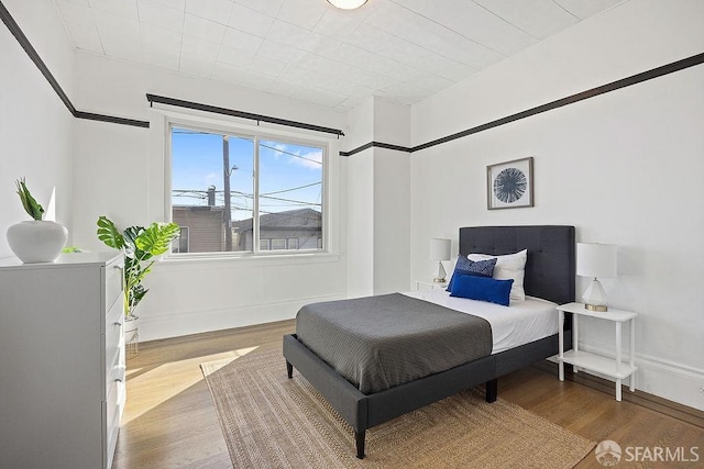 bedroom with baseboards and wood finished floors