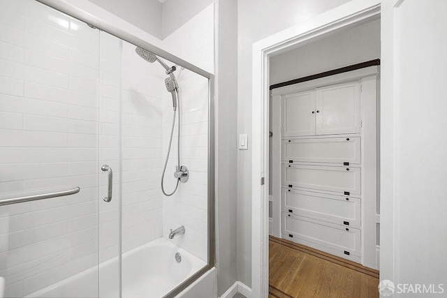 full bathroom featuring shower / bath combination with glass door and wood finished floors