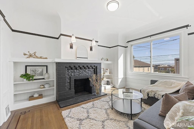 living room with built in features and hardwood / wood-style flooring