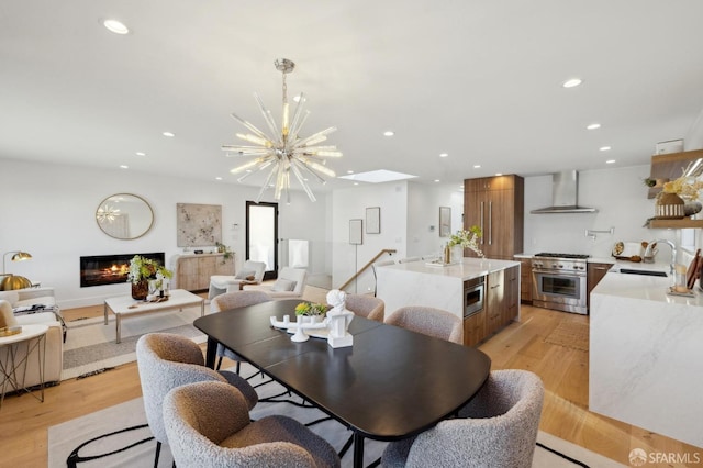 dining space featuring sink, light hardwood / wood-style flooring, and a chandelier