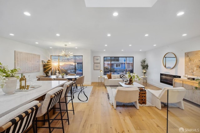 living room with a notable chandelier and light wood-type flooring