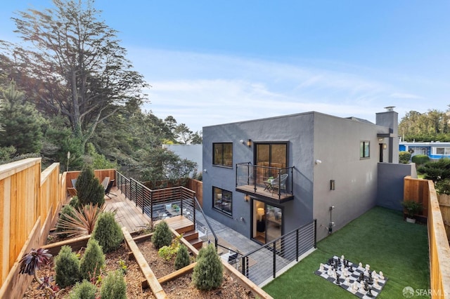 rear view of property with a lawn and a balcony