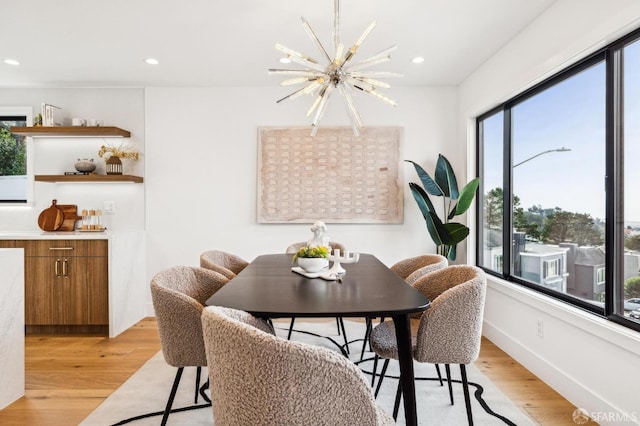 dining area with a notable chandelier and light hardwood / wood-style flooring