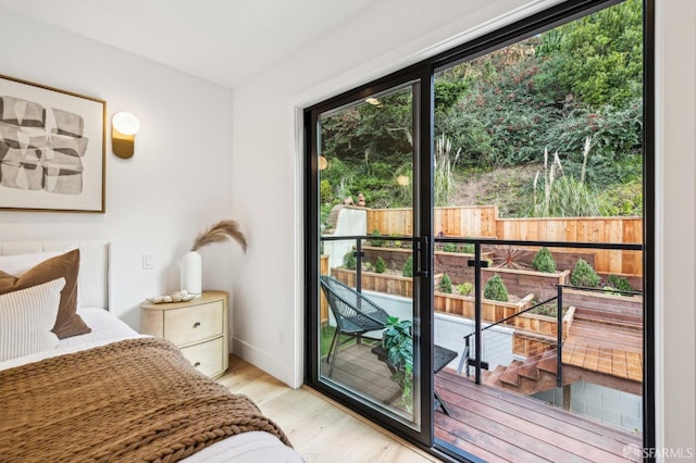 bedroom featuring access to exterior and light wood-type flooring