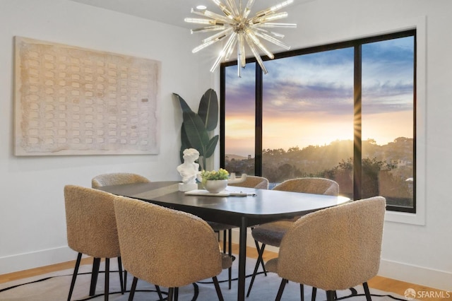 dining space featuring hardwood / wood-style flooring and an inviting chandelier