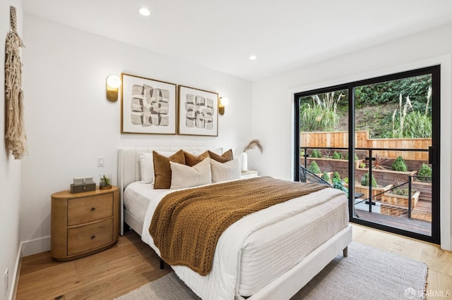 bedroom with access to exterior and light hardwood / wood-style floors