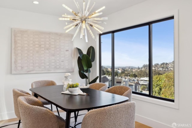 dining space with hardwood / wood-style flooring and a chandelier