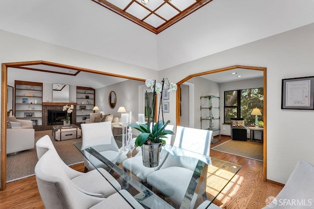35 Ardilla Rd, Orinda, CA 94563 - dining area featuring a brick fireplace, light wood-type flooring, built in shelves, and a high ceiling