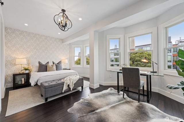 bedroom with an inviting chandelier and dark hardwood / wood-style flooring