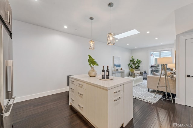 kitchen featuring a center island, dark hardwood / wood-style flooring, a skylight, and hanging light fixtures