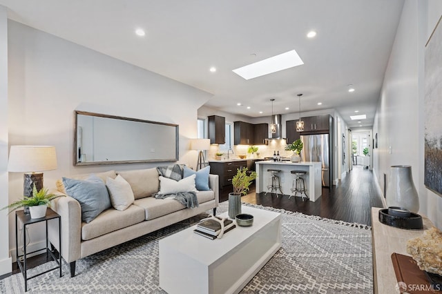 living room featuring dark hardwood / wood-style floors and a skylight