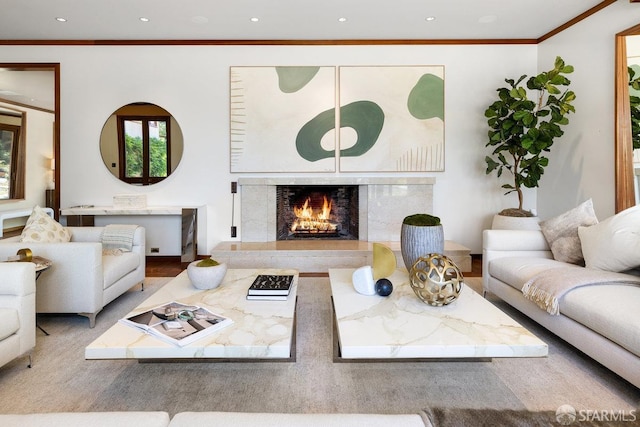 living area with wood finished floors, recessed lighting, crown molding, and a premium fireplace