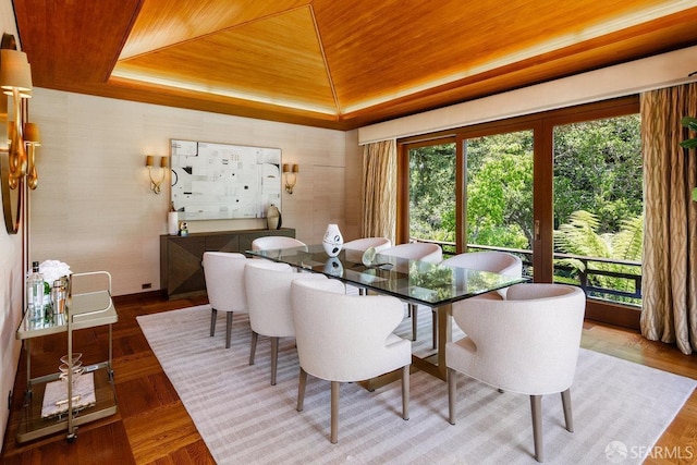dining area featuring a tray ceiling and wood ceiling