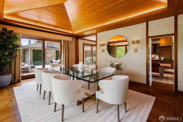 dining room with vaulted ceiling, wooden ceiling, and a raised ceiling