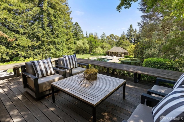 wooden deck featuring an outdoor living space and a view of trees