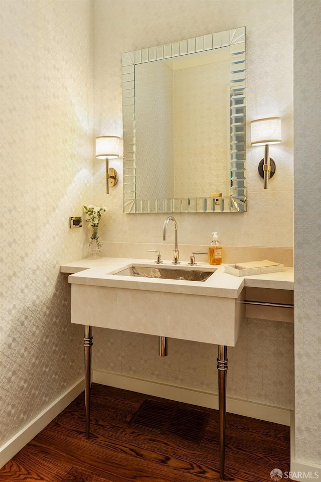 bathroom featuring wood finished floors, visible vents, a sink, and baseboards
