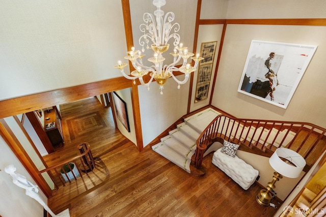 stairway featuring a chandelier and wood finished floors