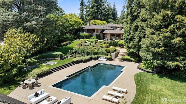 view of swimming pool with a patio and a yard