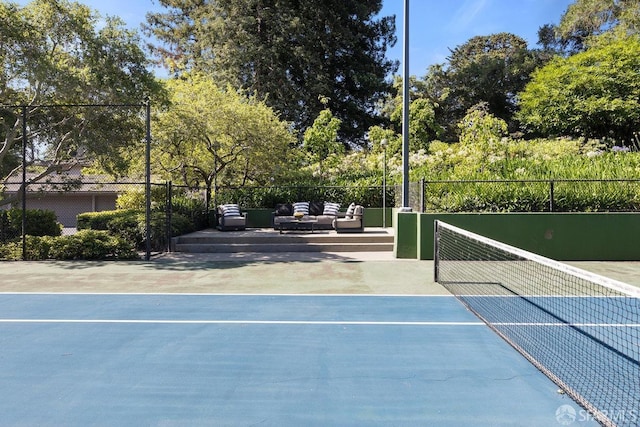 view of tennis court featuring an outdoor living space and fence