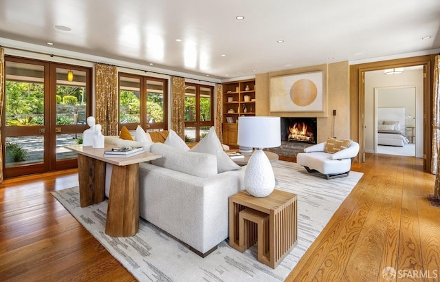 living room featuring a wealth of natural light, french doors, built in features, and wood finished floors