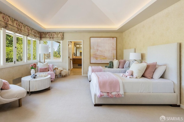 carpeted bedroom featuring a tray ceiling, baseboards, vaulted ceiling, and connected bathroom