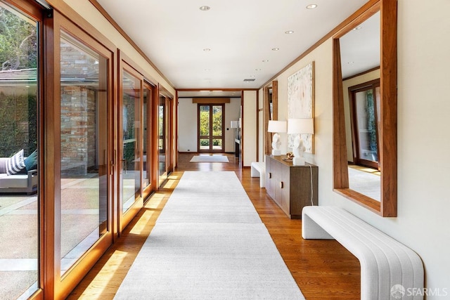 hallway featuring light wood-style flooring and recessed lighting